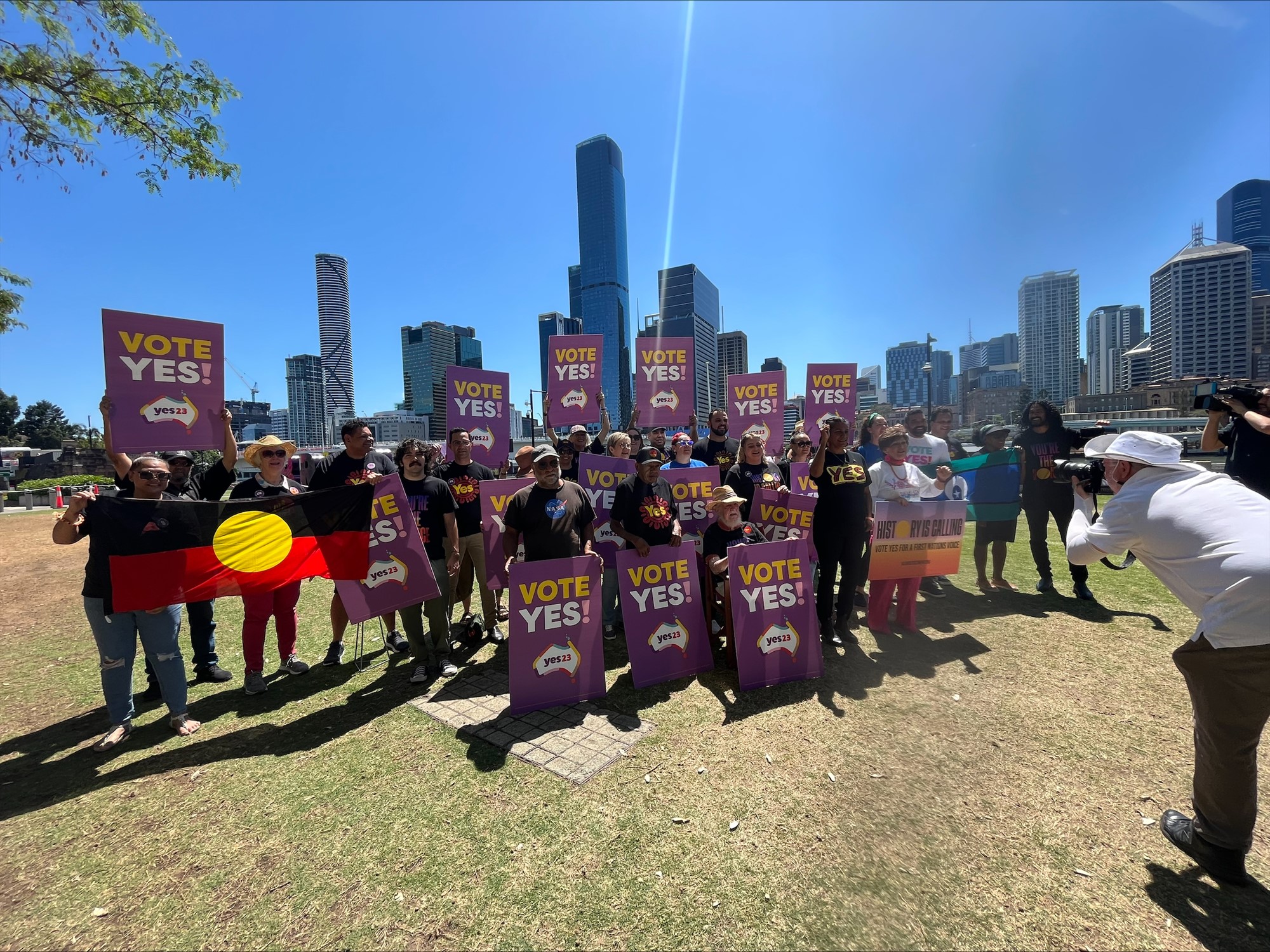 A group of people holding Vote Yes signs gather in South Bank, Brisbane.