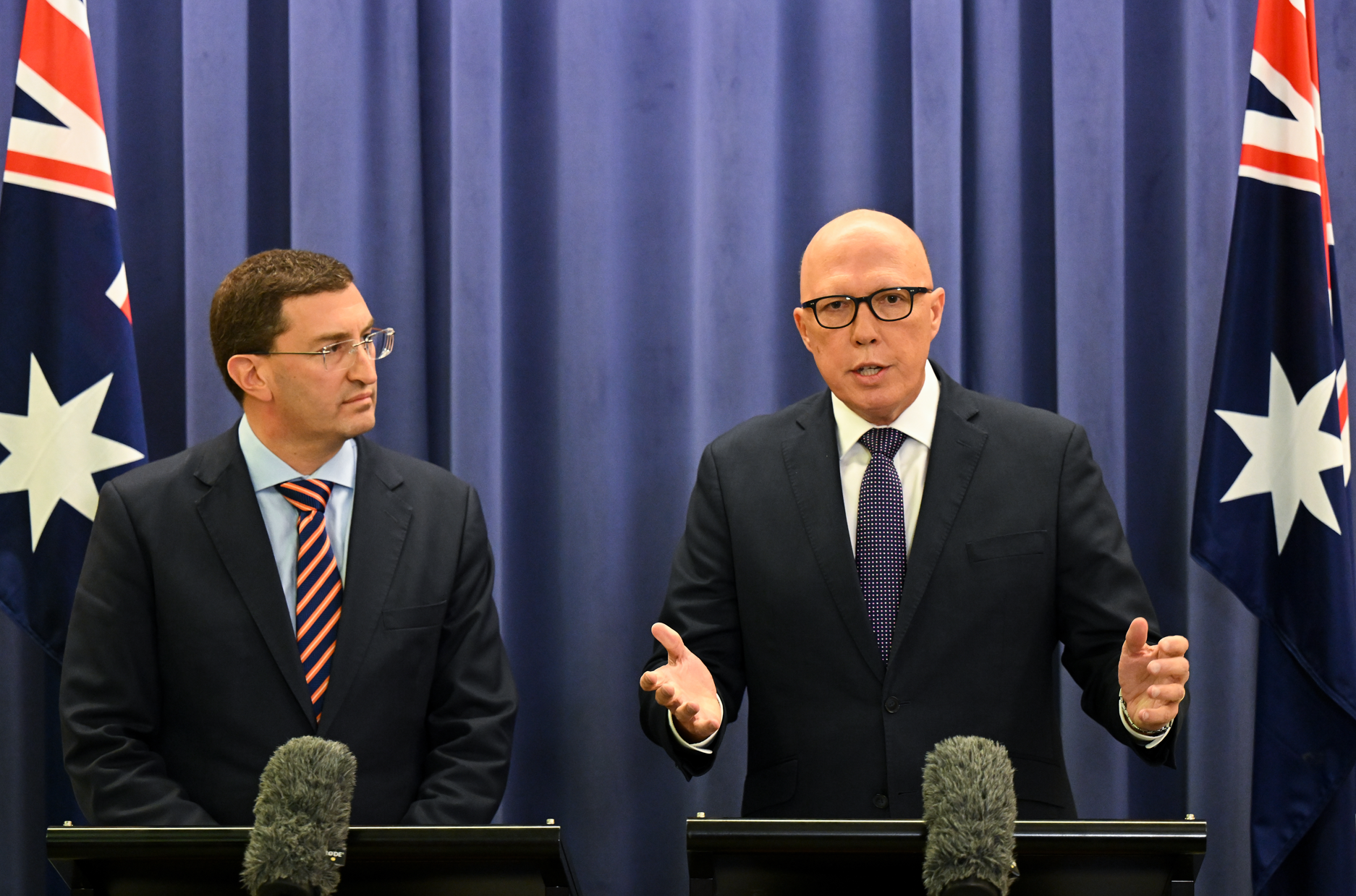 Two men speak during a press conference.