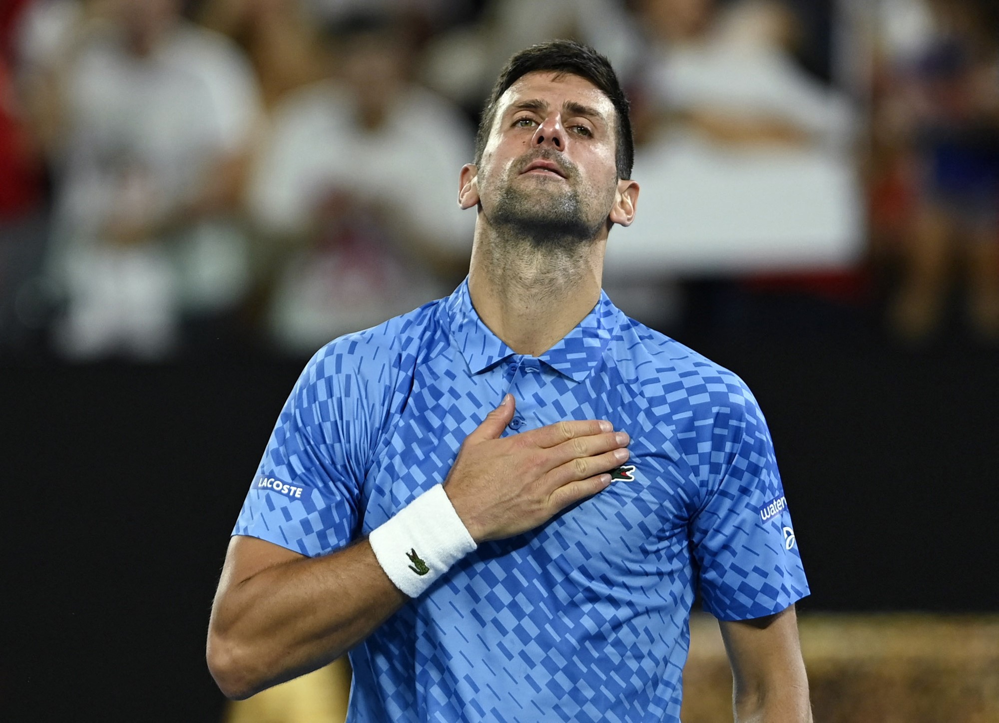 A tennis player with his hand on his chest.