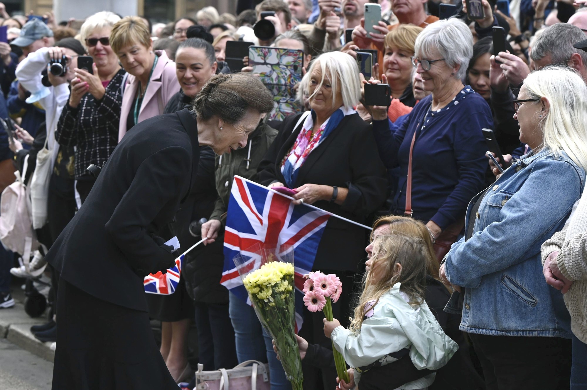 Princess Anne speaking to a child in a crowd