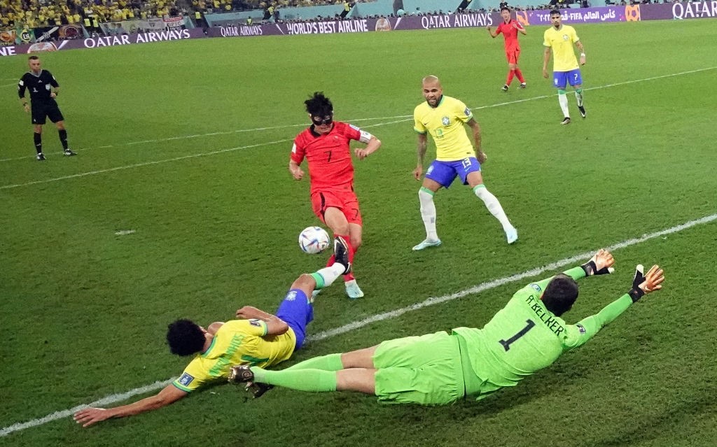Alisson and Marquinhos of Brazil dive in front of South Korea's Son Heung-min's shot on goal.
