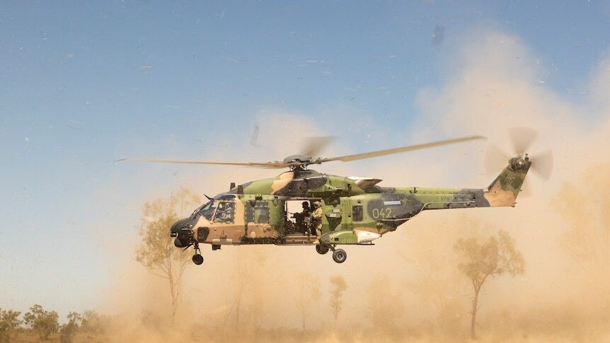Taipan helicopter kicks up dust as it takes off.