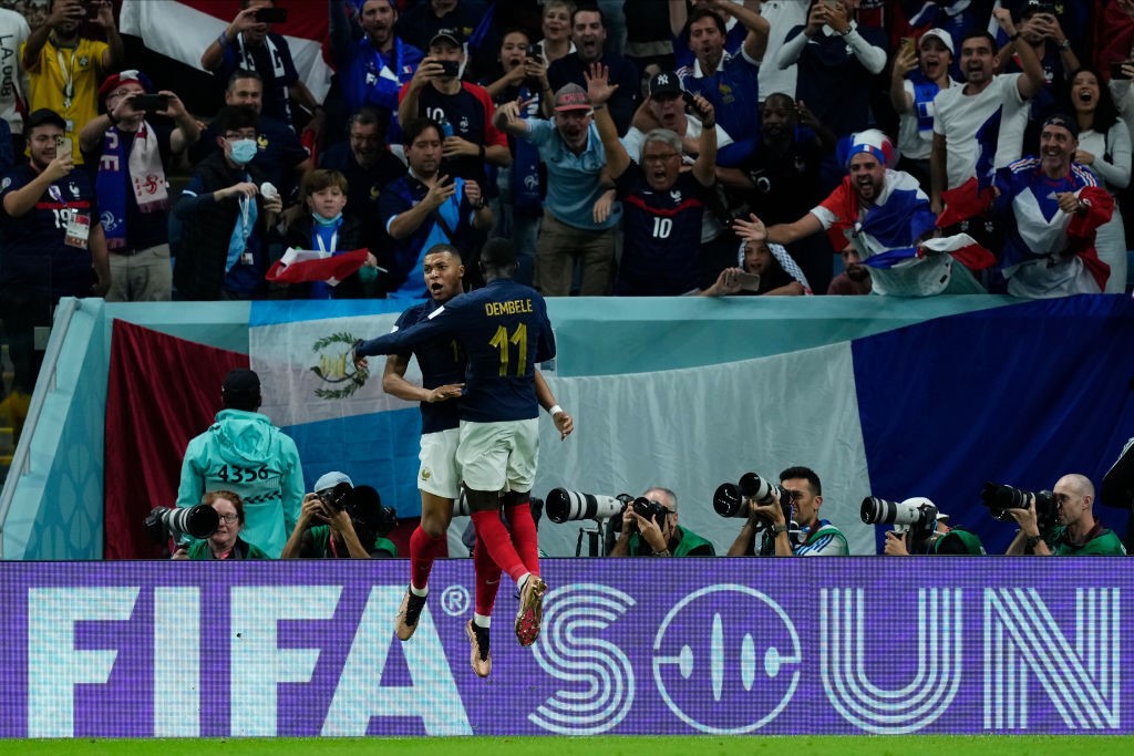 Kylian Mbappe and Ousman Dembele jump and chest each other after a goal for France against Australia at the World Cup.