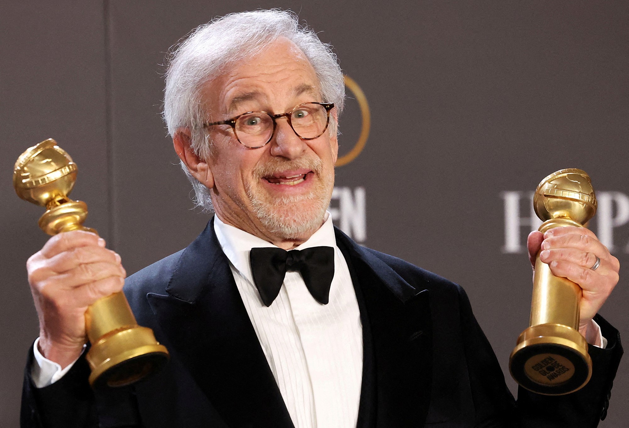 Steven Spielberg holds up two Golden Globes