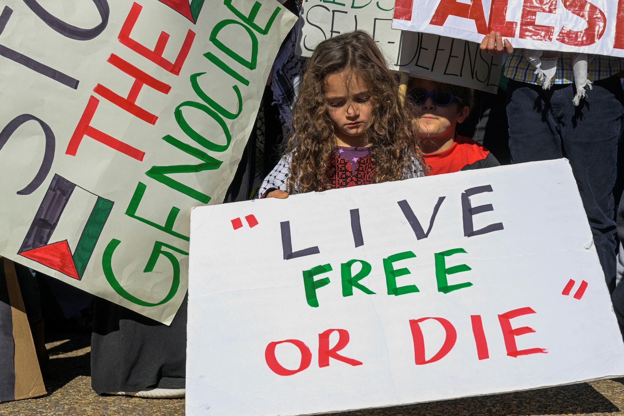 Young girl holds sign saying 'live free or die' 