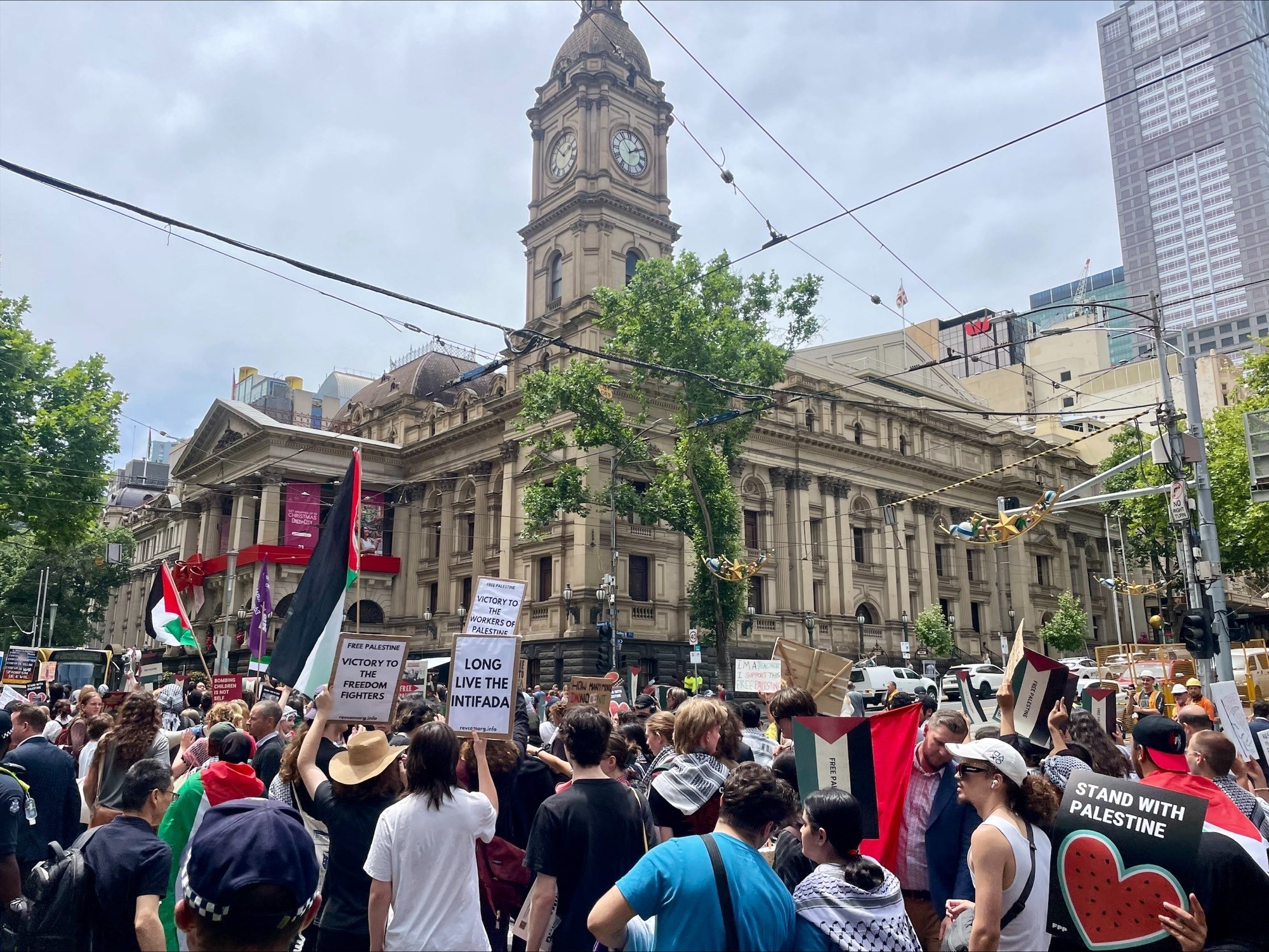 Protesters hold up signs in the Melbourne CBD