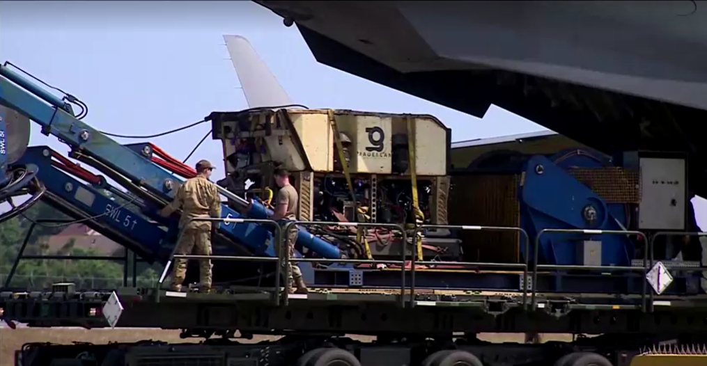 soldiers load an rov onto a large military plane 