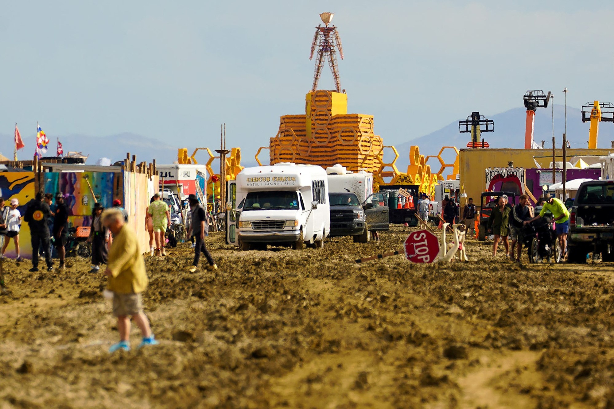 People walk through the mud at Burning Man.