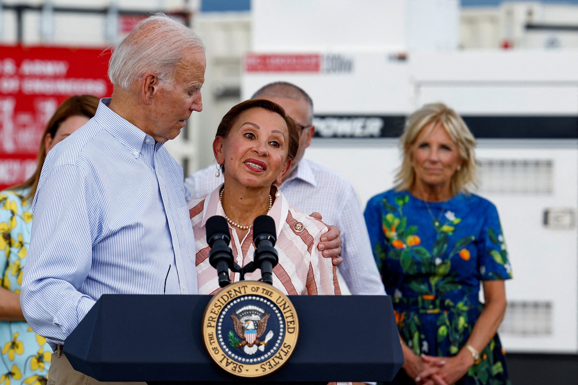 Biden puts his arm around Nydia as they speak at a press conference.