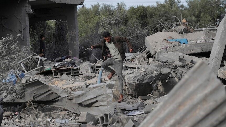 A man walks through an area covered in rubble.