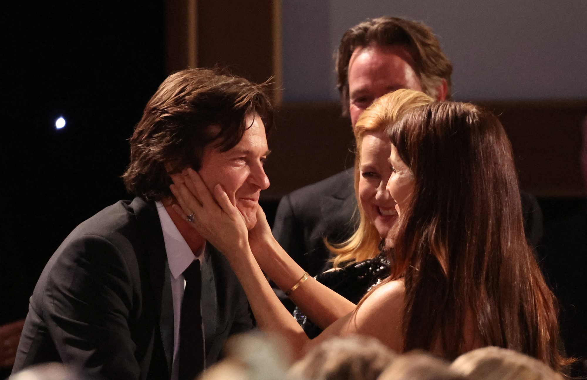 Amanda Anka holds Jason Bateman's head in her hands.