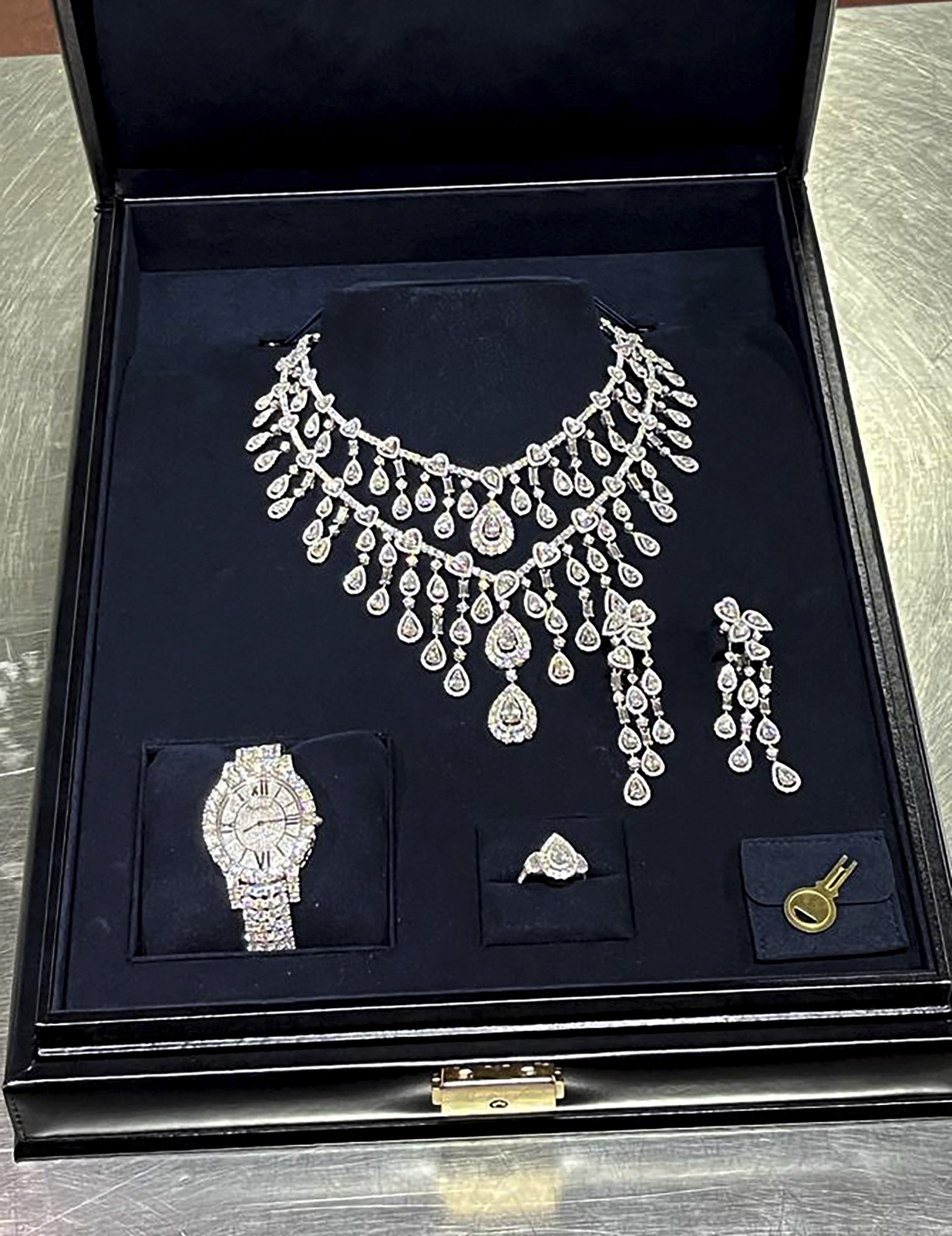 A diamond necklace, ring, earrings and watch in a velvet case. 