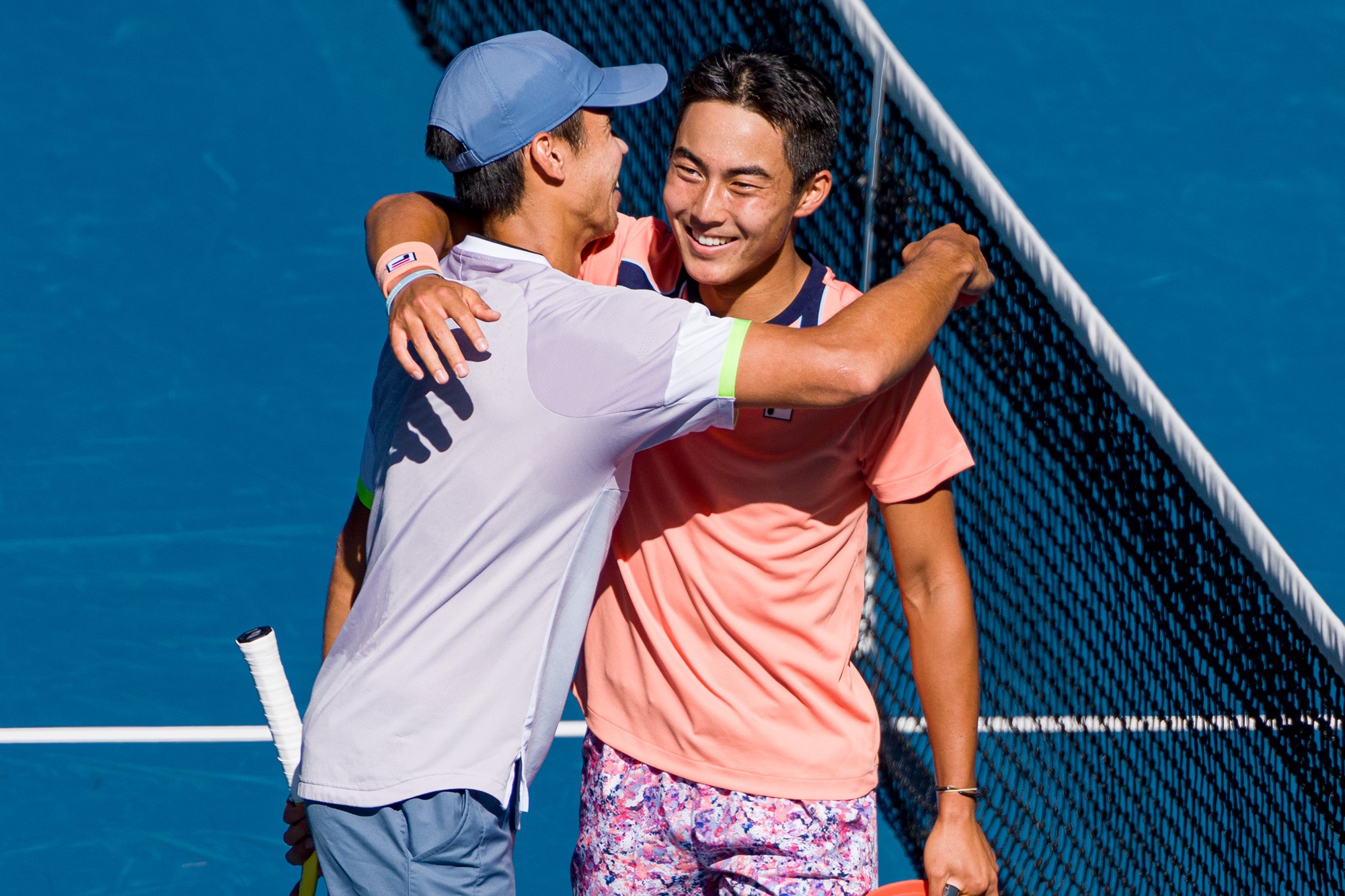 Two tennis plaayers embrace.