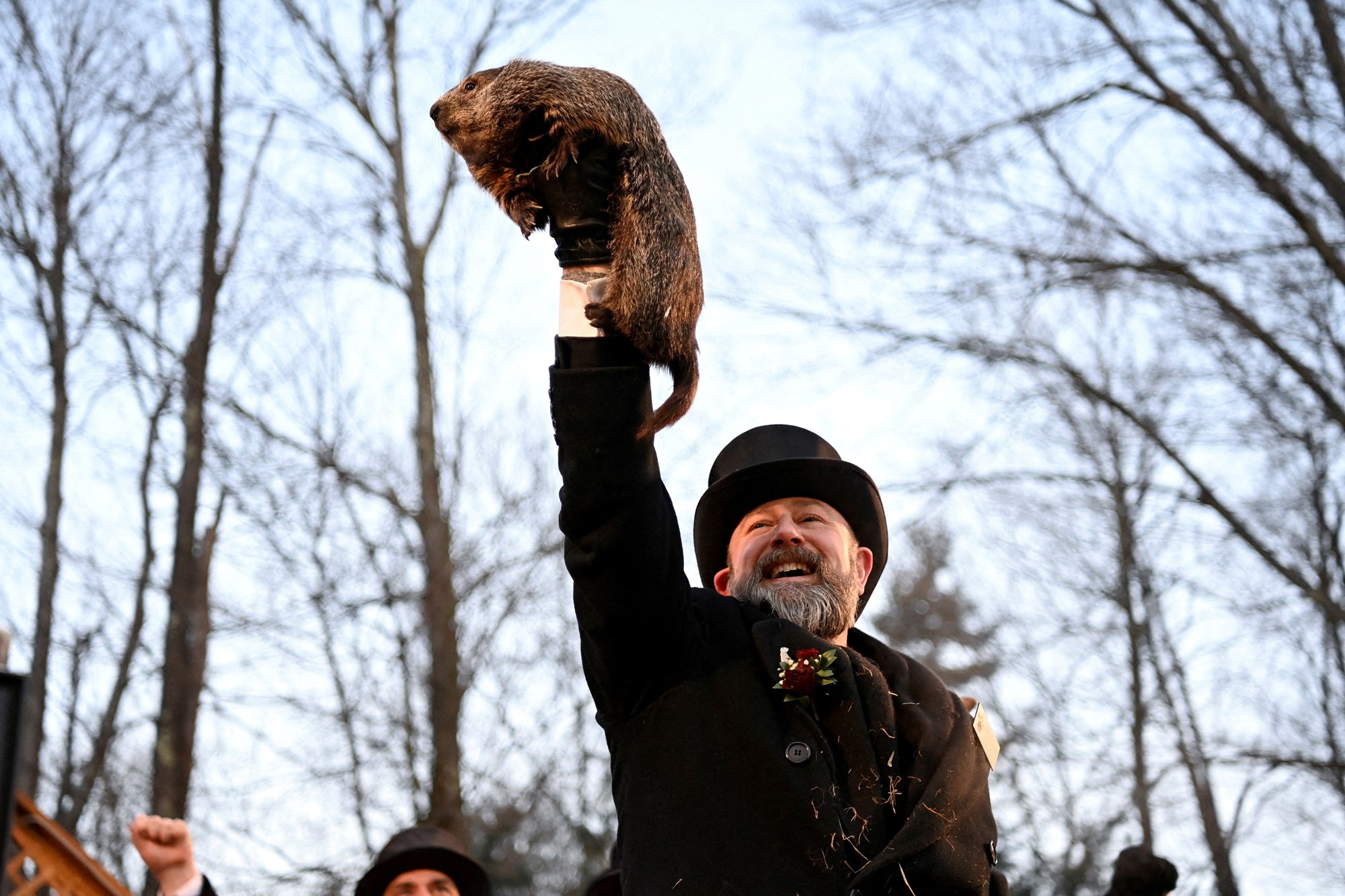 A man holds up a groundhog.