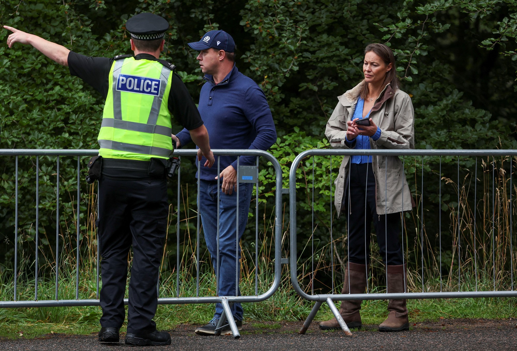 A police officer points to members of the public.