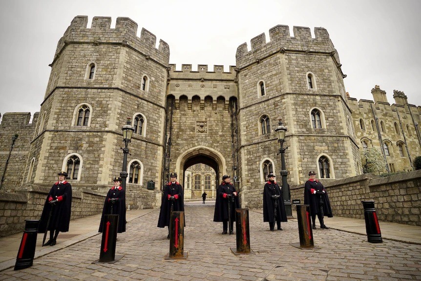 An entrance to Windsor Castle, with officials standing in front