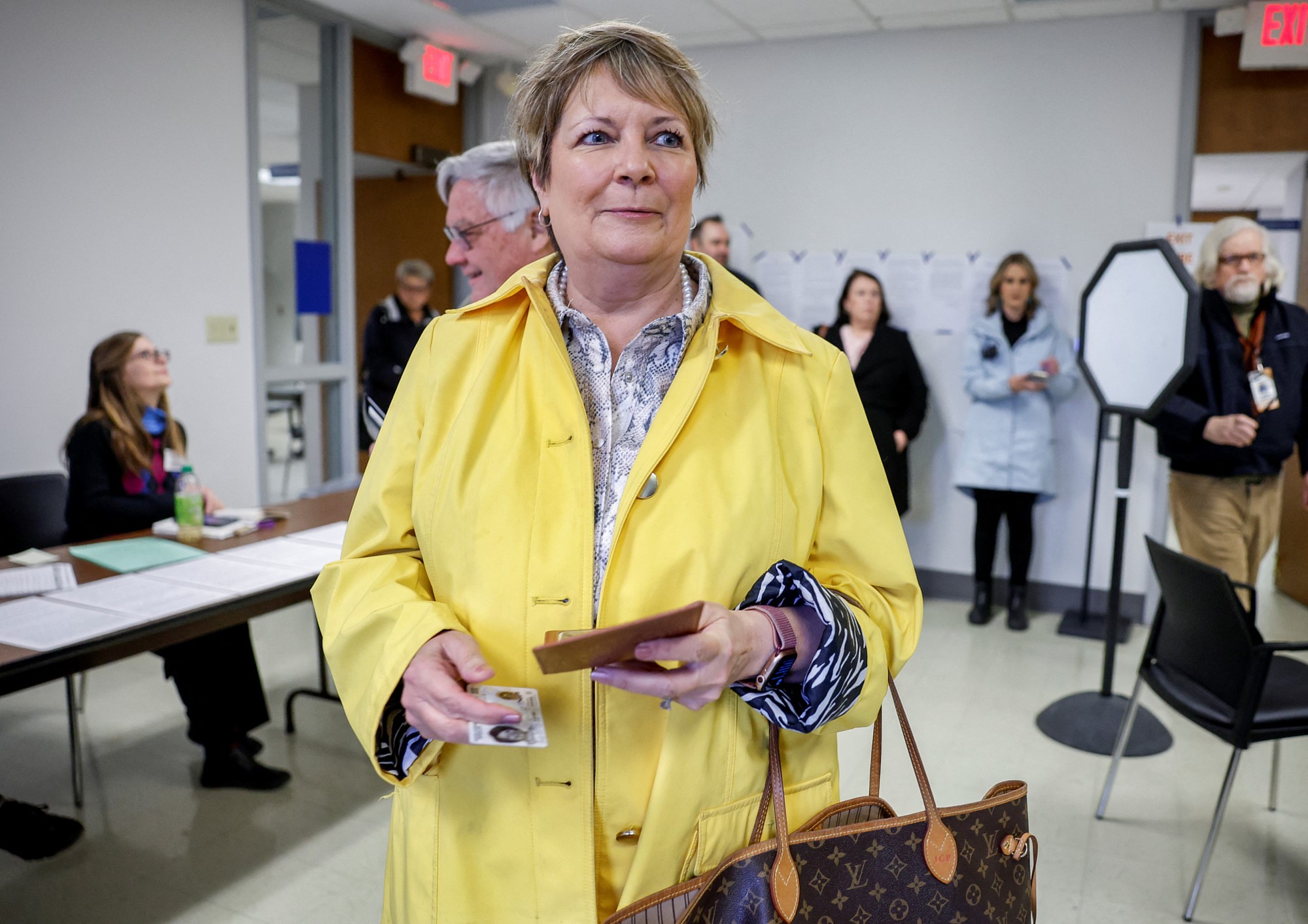 Janet arrives at a polling station in a yellow coat.