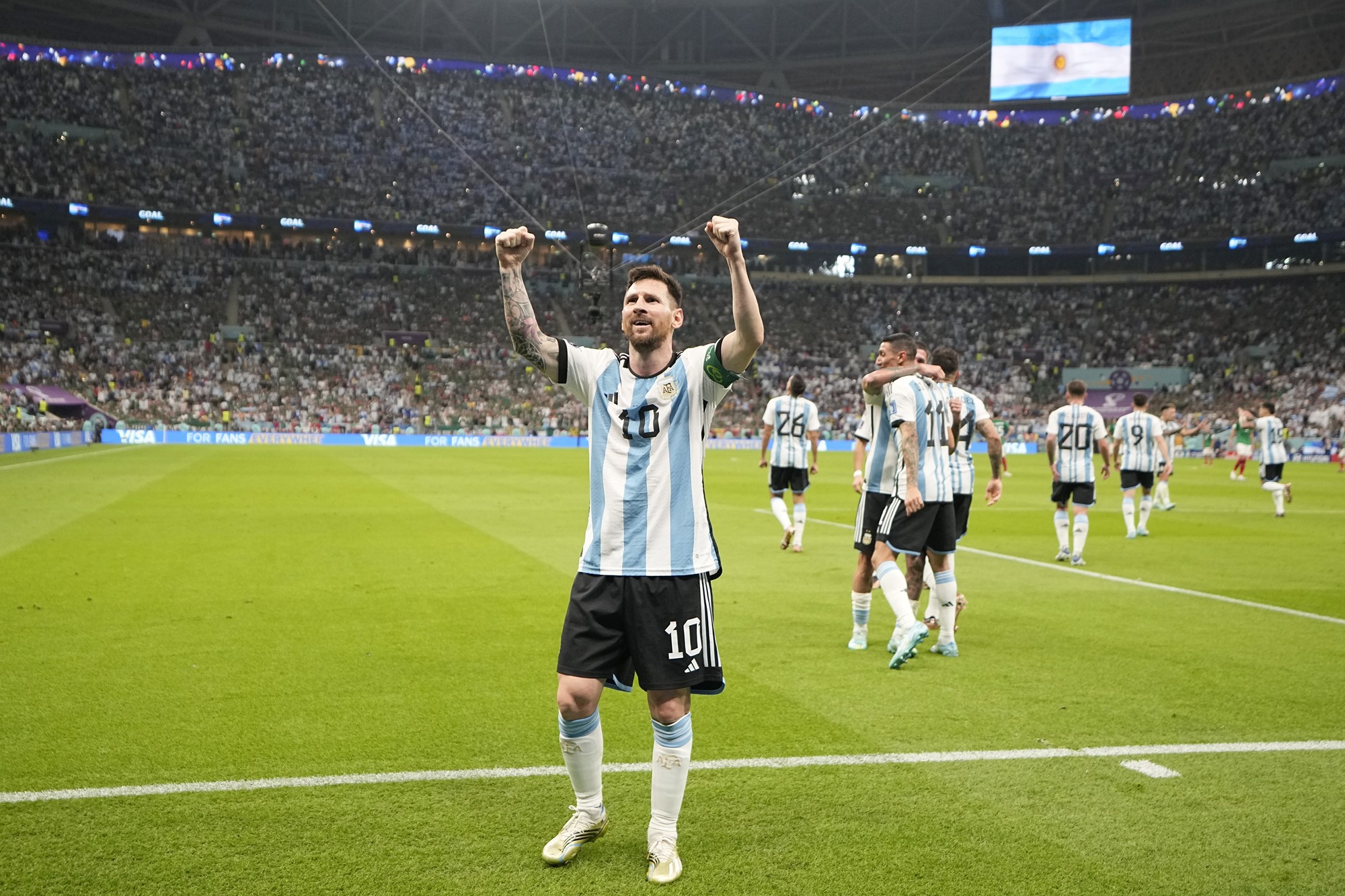 Argentina's Lionel Messi raises his hands above his head in celebration as he salutes the crowd after a win.