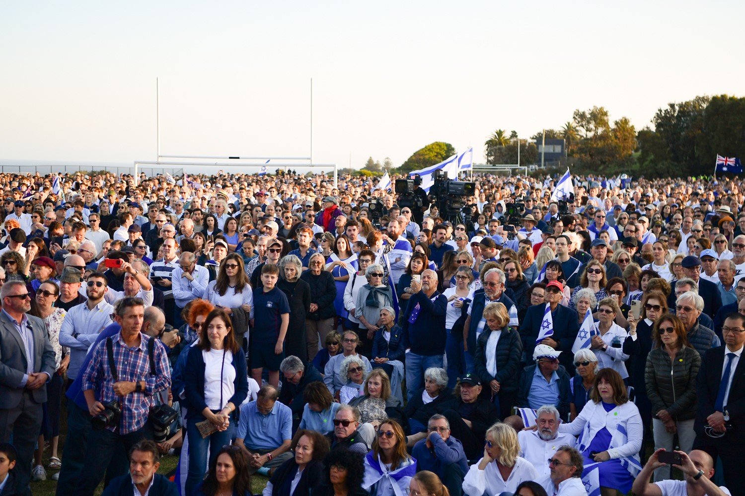 A large group of people is pictured during a ralley carrying Israelian flags.