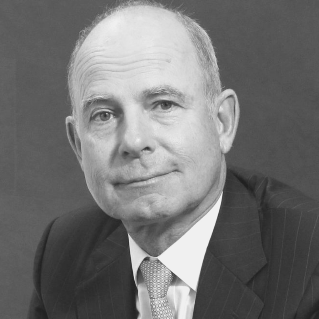 A black and white photo of a bald older man wearing a suit.