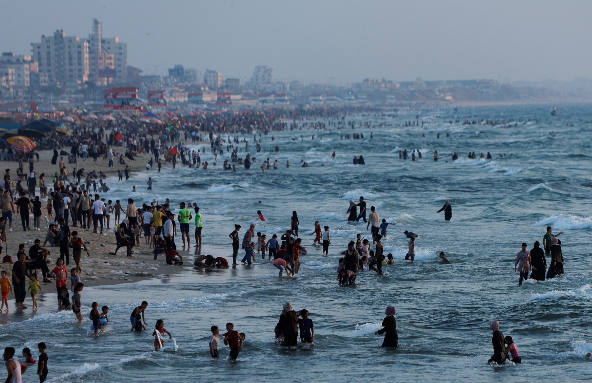 Large groups of people gather at the beach