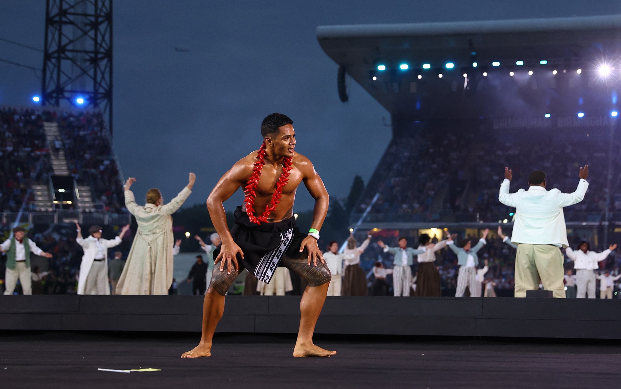 an athlete from samoa in traditional dress dances during the commonwealth games opening ceremony