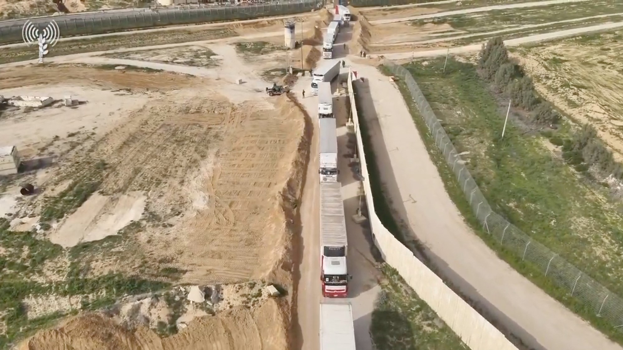 An aerial view of a long line of trucks. 