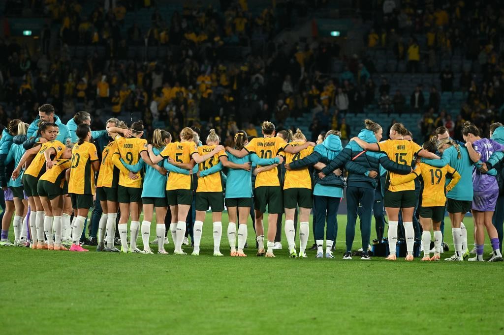Matildas players arm in arm after Australia beat Denmark at the Women's World Cup.