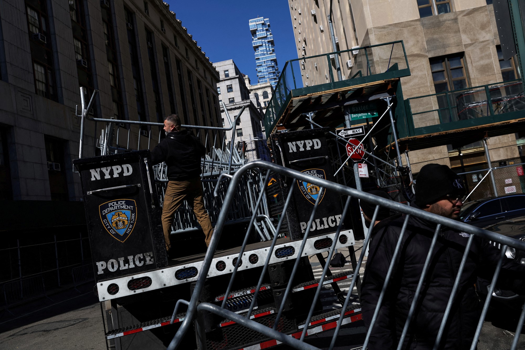 A man sets up a makeshift fence.