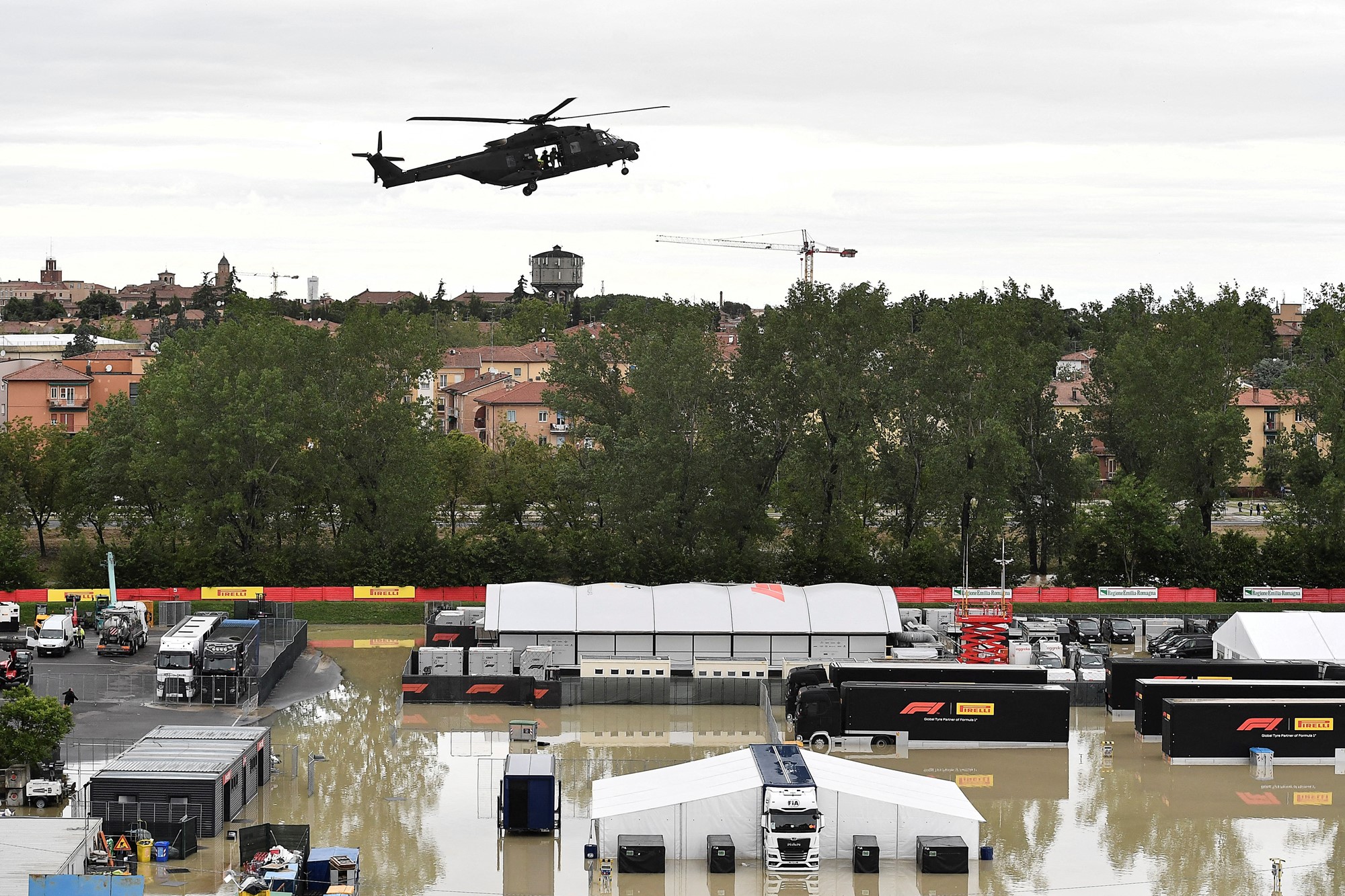 A helicopter flies over a flooded paddock.