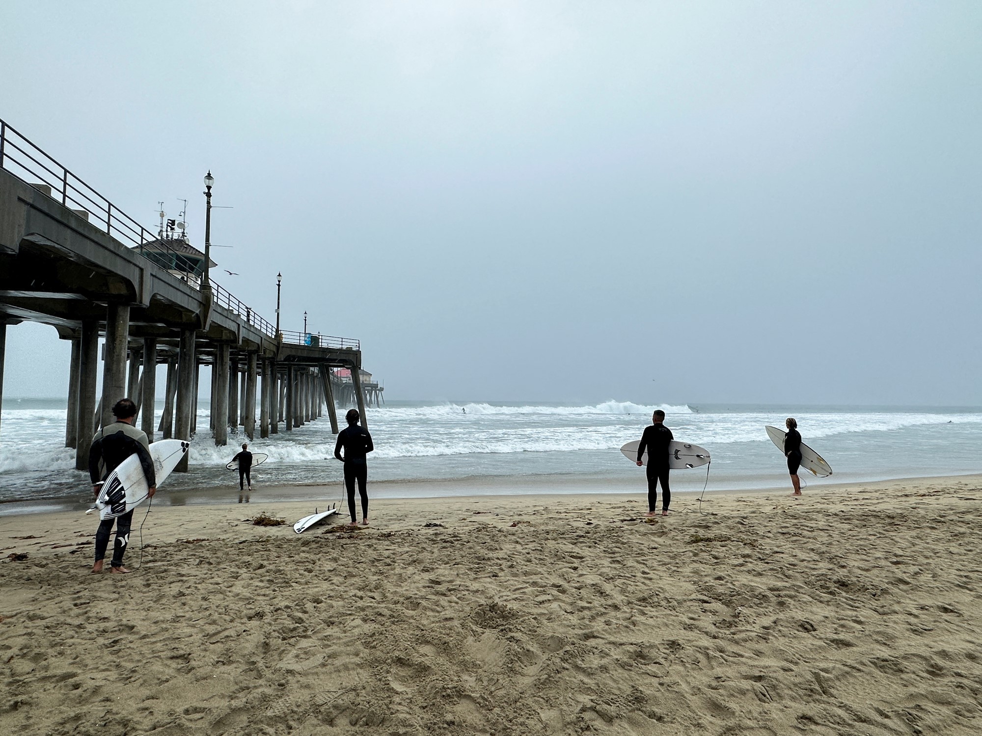 Huntington Beach surfers prepare to ride waves brought on by tropical storm Hilary at Huntington Beach