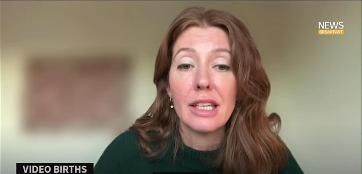 A woman in her thirties with brown hair close up on camera
