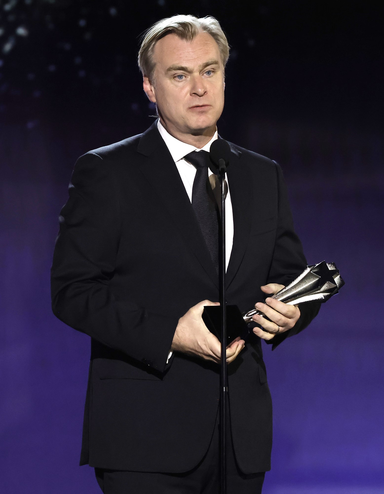 Christopher Nolan holding an award. 