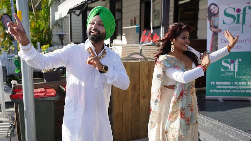 An Indian man and woman dance in the street.