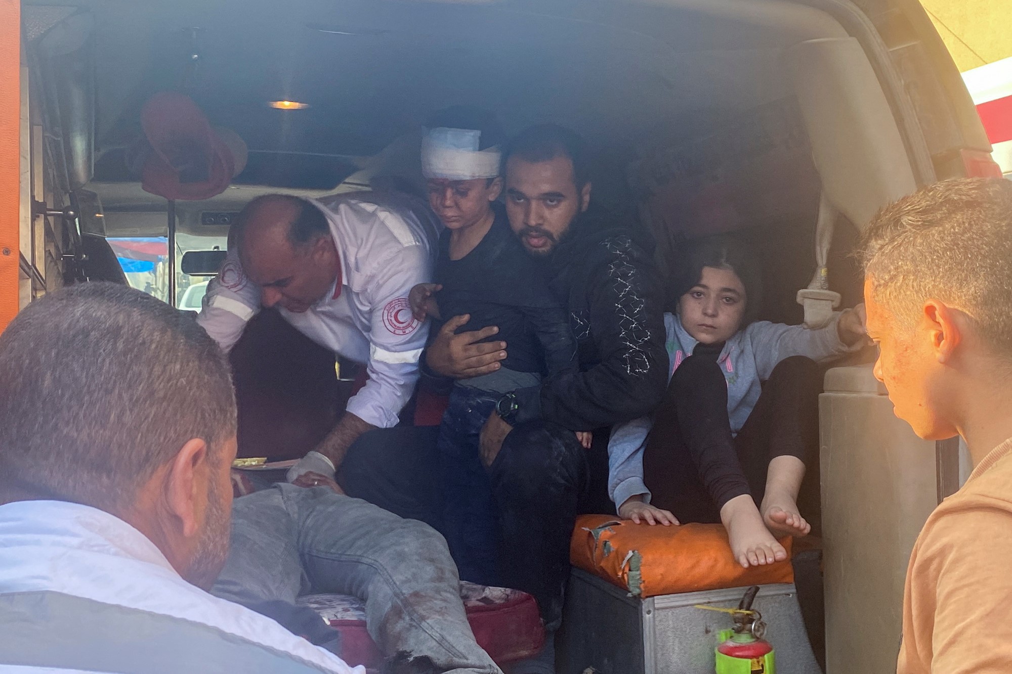 Two children and two adults in the back of an ambulance. 