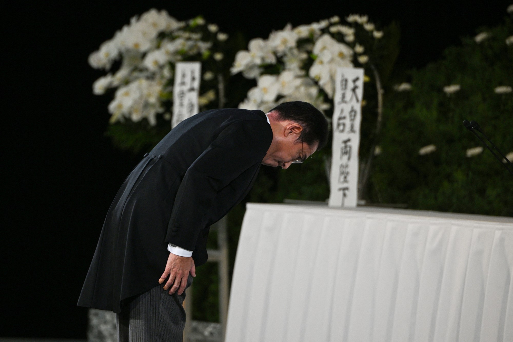 Japan's Prime Minister Fumio Kishida bows toward the altar.