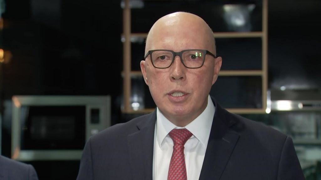 Peter Dutton wearing glasses and a suit and red tie