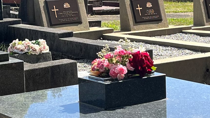 A close-up view of flowers on a gravestone.