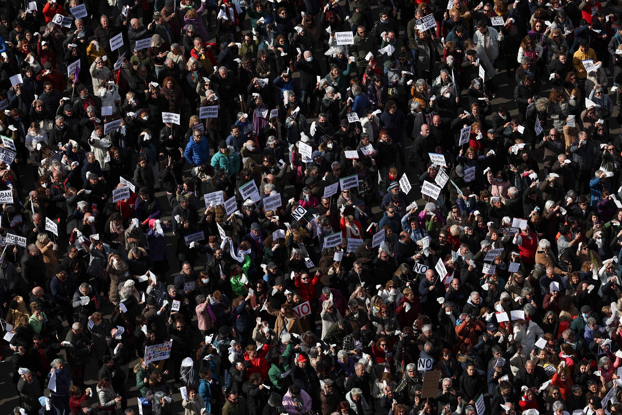 An aerial shot of a protesting crowd holding signs - people fill the entire photo.