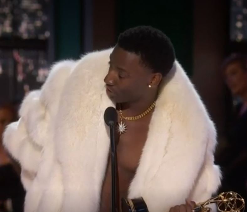 Jerrod Carmichael in a white fur coat and no shirt