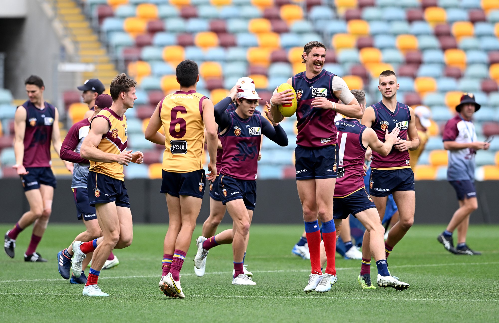 Lions players smile while running on the Gabba