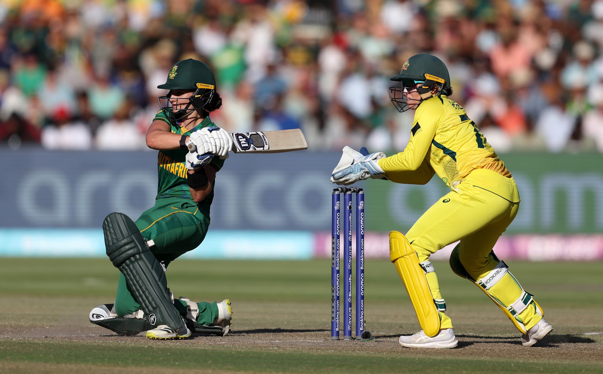 South Africa batter Laura Wolvaardt completes a shot as Australia wicketkeeper Alyssa Healy looks on.