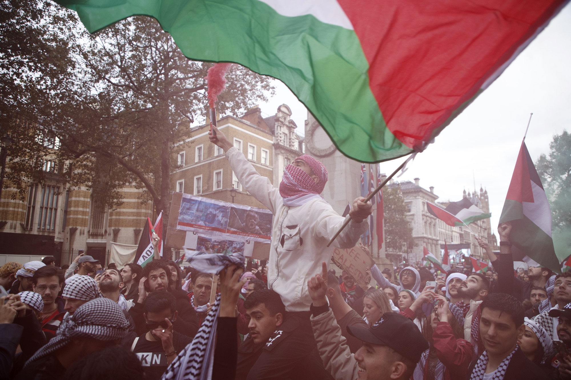 Demonstrators hold up flares, flags and placards during a pro Palestinian demonstration in London