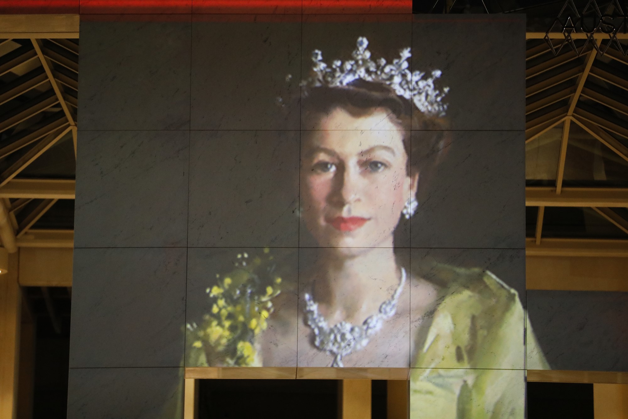 A projection of Parliament House shows Queen Elizabeth II as a young woman.