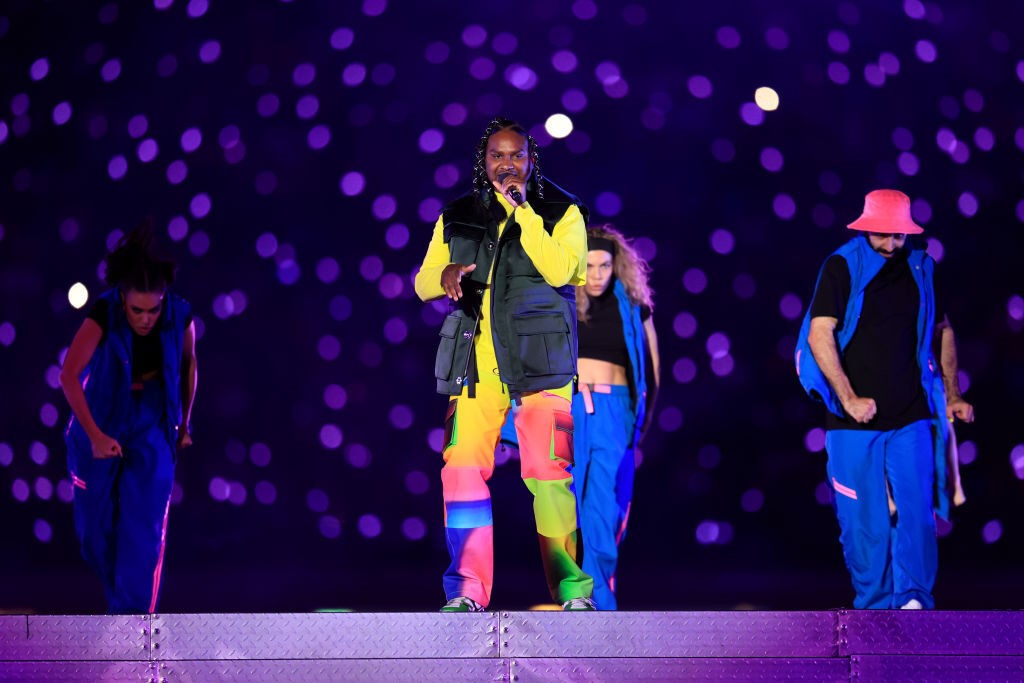 australian artist baker boy sings on stage at commonwealth games closing ceremony with backup dancers