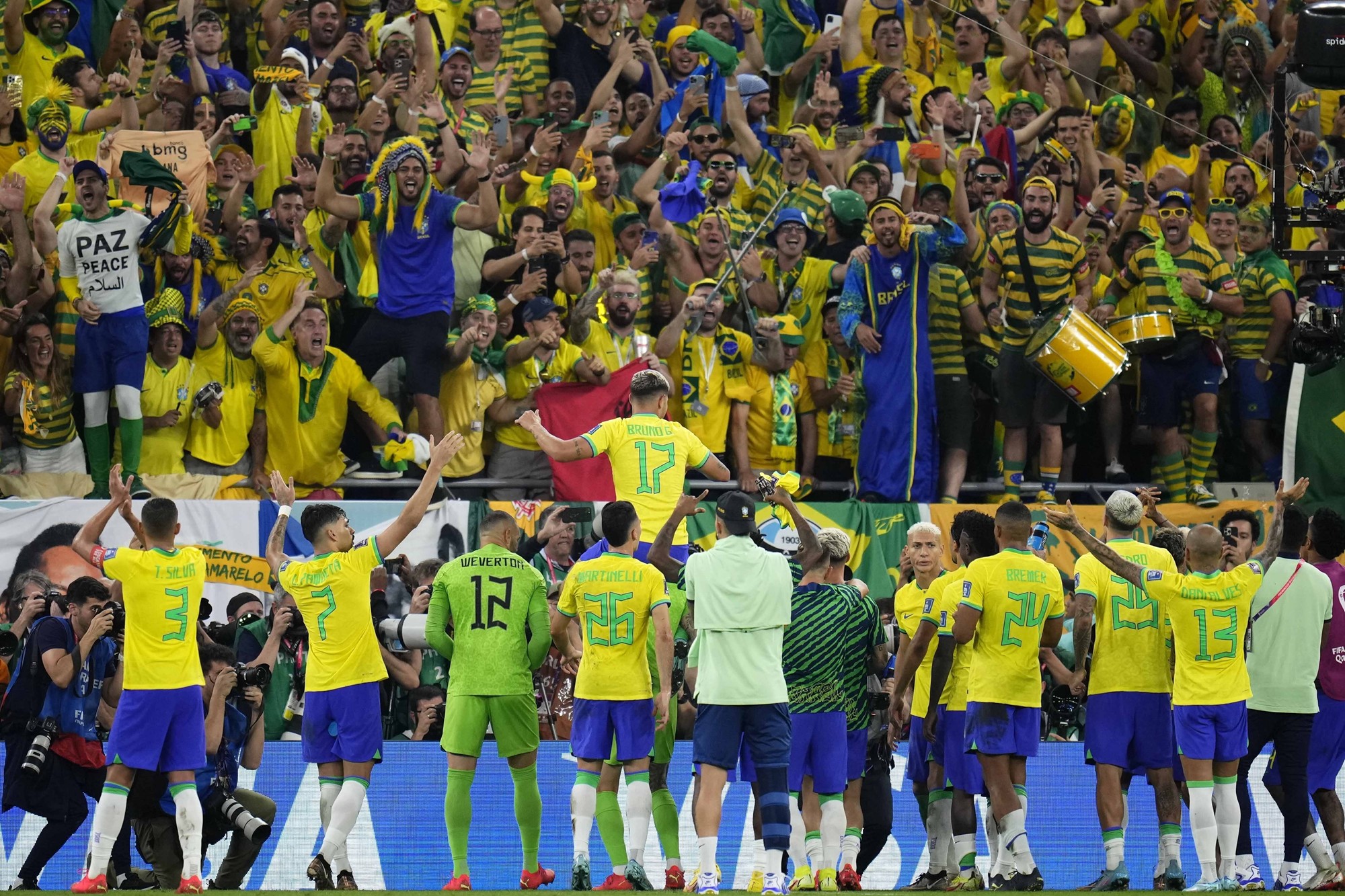 Brazil players celebrate with Brazil fans after beating South Korea at the FIFA World Cup in Qatar.