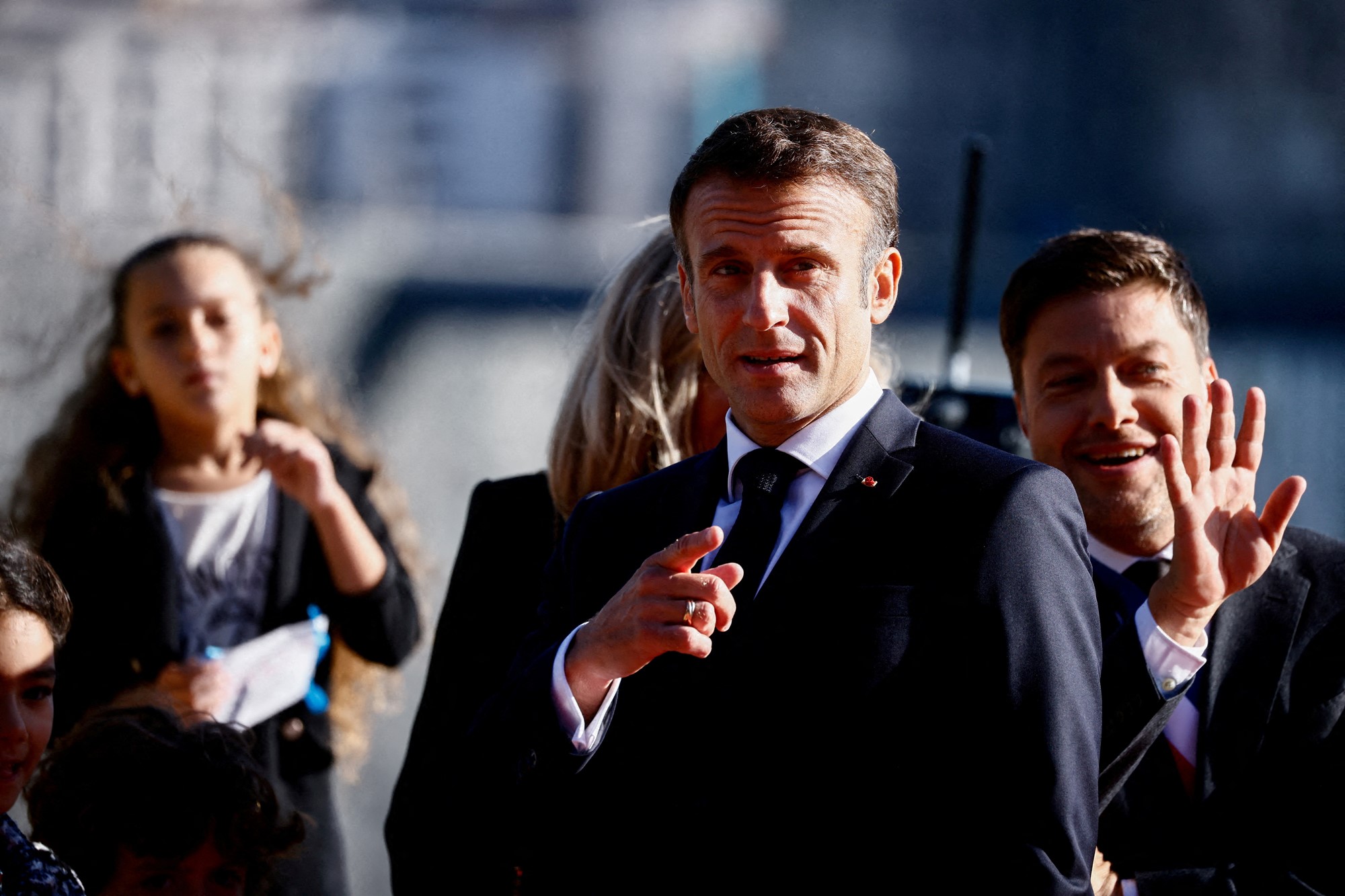 A mid shot of Emmanuel Macron pointing with his right hand.