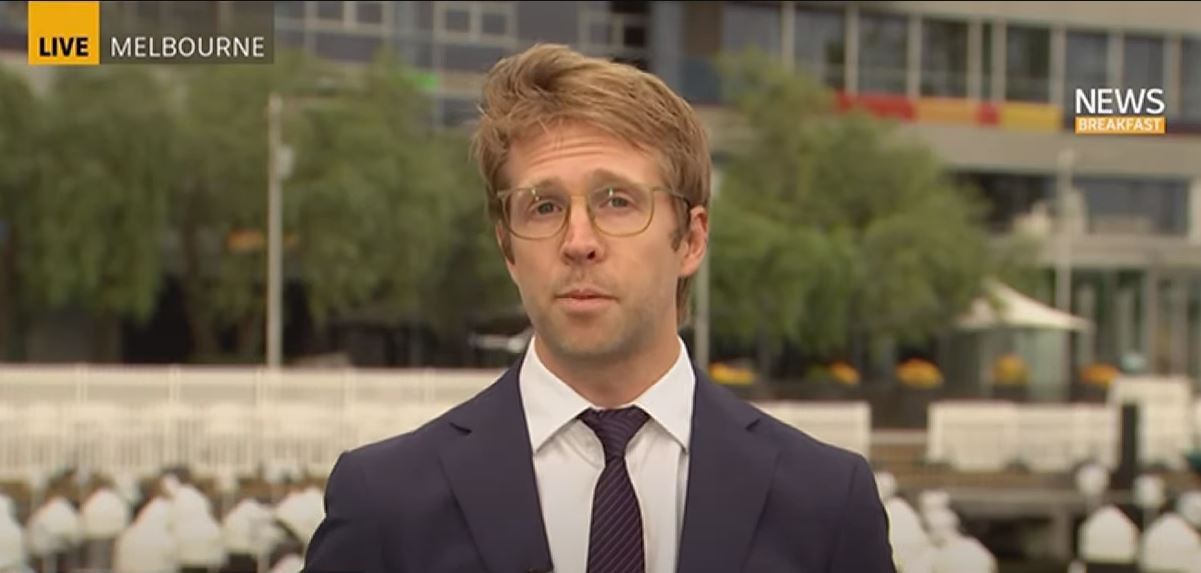 A man in a suit in front of a building. 