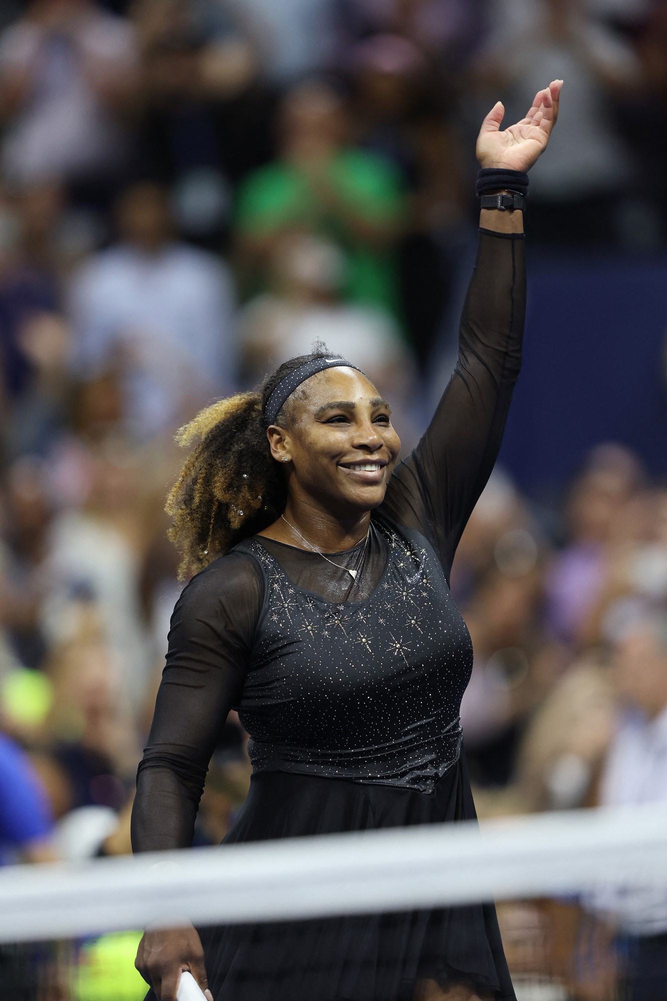 A woman in a black outfit celebrates after winning tennis.