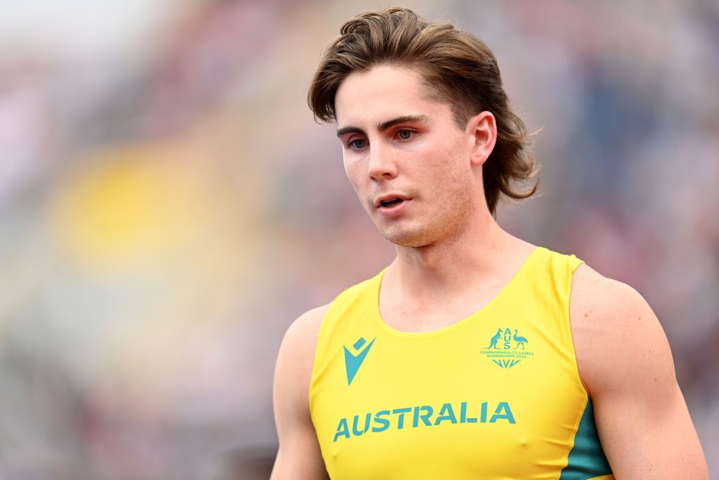 rohan browning walks looking downwards, his hair is cut in a mullet style